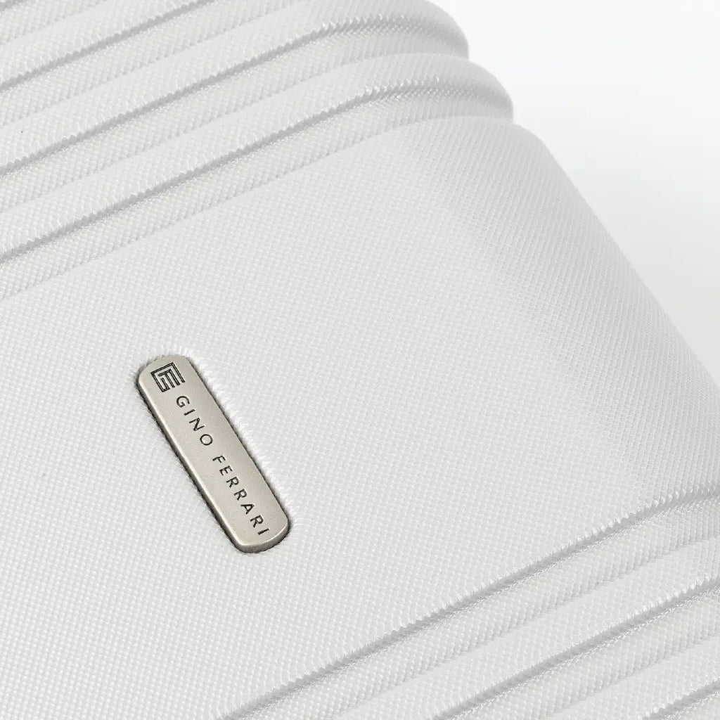 Close-up of a silver hard-shell suitcase with a visible brand logo 'Gino Ferrari'.
