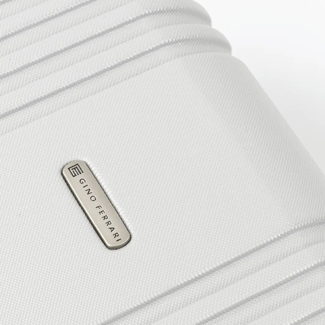 Close-up of a silver hard-shell suitcase with a visible brand logo 'Gino Ferrari'.