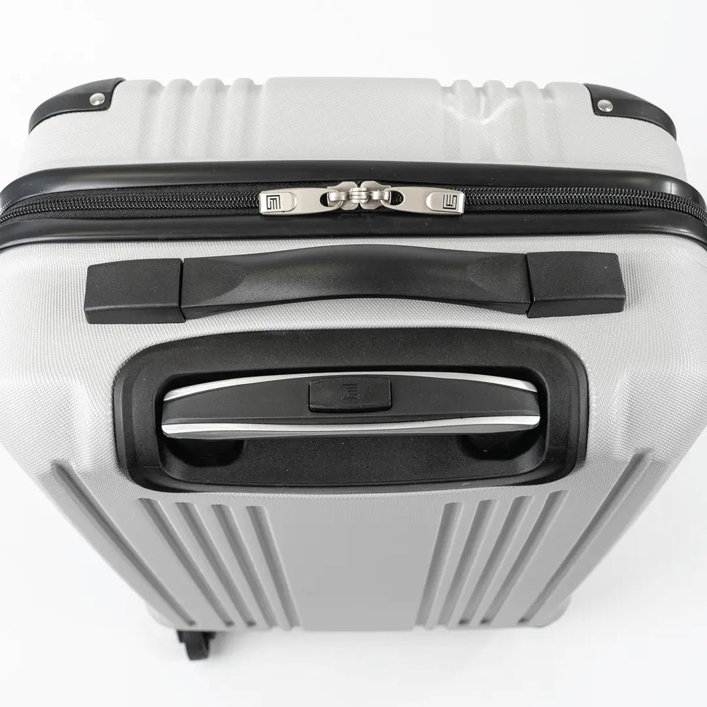 Close-up of a silver hard-shell suitcase with black accents.