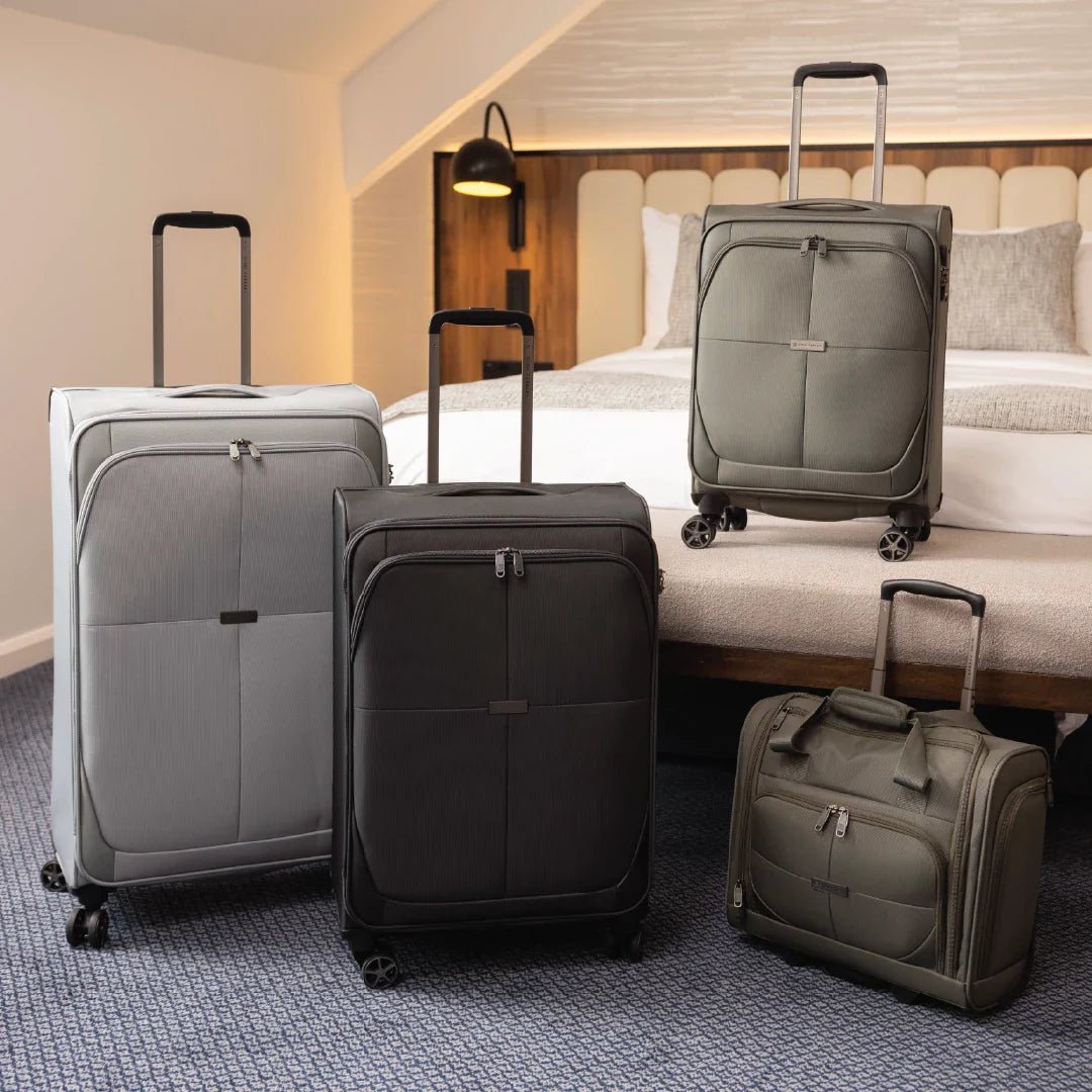 Four suitcases of different sizes in a hotel room setting.