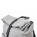 Light gray backpack with a black strap on a white background