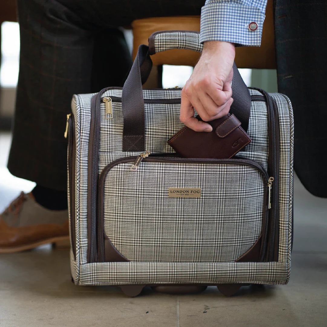 Person holding a plaid patterned suitcase with a matching wallet.