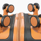 Close-up of a black and orange suitcase with wheels on a white background
