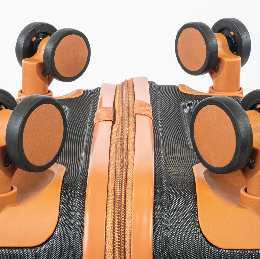 Close-up of a black and orange suitcase with wheels on a white background