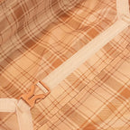Close-up of a plaid fabric with a beige strap and buckle.