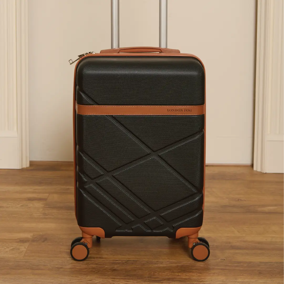 Black suitcase with brown accents on a wooden floor