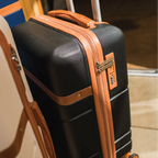 Black suitcase with orange accents on a wooden floor