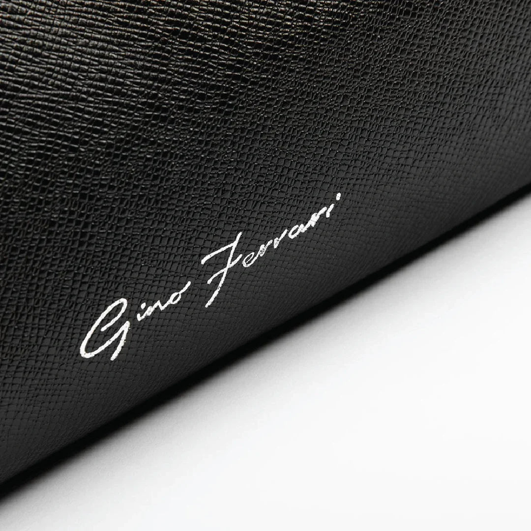 Close-up of a black textured surface with 'Gino Ferrari' branding.